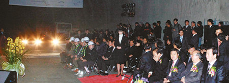 13일 국내 최장 터널인 부산 금정터널 관통 기념식장에서 갑자기 전기가 끊겨 터널 내부가 깜깜해지자 정종환 국토해양부 장관과 허남식 부산시장 등 참석자들이 차량 전조등에 의지해 전기가 들어오기를 기다리고 있다. 부산=연합뉴스