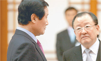 윤증현 기획재정부(왼쪽)이 12일 청와대에서 임명장을 받기 전에 전임 장관인 강만수 국가경쟁력강화위원장과 진지한 표정으로 정책 현안에 대해 이야기를 나누고 있다.