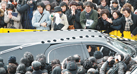 “편히 쉬십시오” “김수환 스테파노 추기경님! 떠나는 길을 막지 못하더라도 영원히 잊지 않겠습니다.” 20일 서울 명동성당에서 김 추기경의 장례미사가 끝난 뒤 운구 차량이 성당을 빠져나가는 길에서 두손 모아 기도하고 흰 미사포를 흔드는 시민들. 모두 추기경의 가르침인 사랑을 되새기는 모습이다. 변영욱 기자