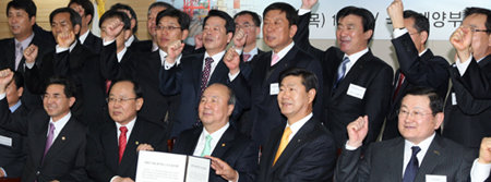 5일 국토해양부 대회의실에서 열린 ‘경제위기 극복을 위한 항만노사정 공동선언식’에서 최봉홍 전국항운노동조합연맹 위원장과 정종환 국토해양부 장관, 이국동 한국항만물류협회장(앞줄 왼쪽에서 두 번째부터) 등 관계자들이 항만노동자 임금과 항만하역 요금 동결에 합의한 뒤 약속 이행을 다짐하는 구호를 외치고 있다. 연합뉴스