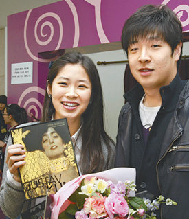 10만 번째 주인공 김태은 씨서울 예술의전당에서 열리는 ‘클림트의 황금빛 비밀’전을 찾은 김태은 씨(왼쪽)가 8일 오후 10만 번째 관객이 됐다. 남자친구와 함께 클림트전을 찾은 김 씨가 축하 꽃다발과 선물을 받고 활짝 웃고 있다. 변영욱 기자