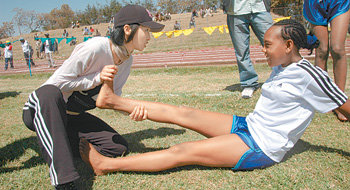 쥐 날 땐 이렇게 박정아 씨(왼쪽)가 6일 에티오피아 아르시에서 열린 희망 마라톤대회에서 오른다리에 쥐가 난 소녀를 보살피고 있다. 아르시=김재명 기자