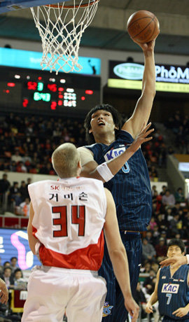 “높긴 높네” 국내 프로농구 최장신(222cm)인 KCC 센터 하승진(위)이 자신보다 15cm 작은 SK 그레그 스팀스마(207cm)가 넋을 놓고 쳐다보는 가운데 골밑 슛을 시도하고 있다. 연합뉴스