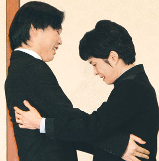 1987년 대한항공기 폭파 사건의 범인 김현희 씨(47·오른쪽)가 11일 부산 벡스코에서 북한에 납치된 일본인 다구치 야에코 씨의 아들 이즈카 고이치로 씨(32)를 만나 인사를 나누며 감정이 북받치는 듯 눈물을 보이고 있다. 다구치 씨는 1978년 납치된 뒤 북한에서 김 씨에게 일본어를 가르쳤다. 김 씨는 1997년 5월 공안검사를 대상으로 강연을 한 이후 12년 만에 공식적인 자리에 모습을 나타냈다. 부산=최재호 기자