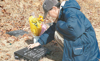 1년 전 시신이 토막 난 채 발견된 이혜진 양의 아버지 이창근 씨가 10일 경기 의왕시의 청계공원묘지에 있는 딸의 묘비 앞에 앉아 비석을 매만지고 있다. 의왕=유덕영 기자