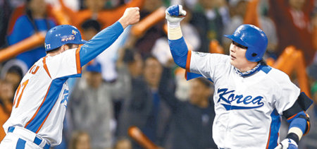 야구 대표팀 김태균(오른쪽)이 16일 미국 샌디에이고 펫코파크에서 열린 제2회 월드베이스볼클래식(WBC) 8강 라운드 멕시코와의 첫 경기에서 2-2로 맞선 4회 역전 솔로홈런을 날린 뒤 류중일 3루 코치와 주먹을 맞대고 있다. 한국은 2회 이범호, 4회 김태균, 5회 고영민의 솔로홈런 등 장단 12안타를 터뜨려 멕시코를 8-2로 크게 이겼다. 한국은 앞선 경기에서 쿠바를 6-0으로 꺾은 일본과 18일 낮 12시 4강 티켓을 놓고 승자 결승전을 치른다. 샌디에이고=연합뉴스