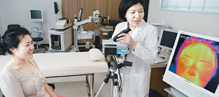 아모레퍼시픽 기술연구원 항온항습실에서 한 연구원이 화장품 효능실험 참가자의 피부 온도를 특수 카메라를 이용해 측정하고 있다. 모니터를 통해 확인되는 피부색은 온도가 높을수록 희게, 낮을수록 검게 나타난다. 사진 제공 아모레퍼시픽