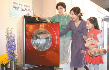 삼성전자가 보낸 세탁 전문가(가운데)가 하우젠 버블 세탁기 사용자에게 찌든 때를 세탁하고, 에너지 소비를 줄일 수 있는 방법 등을 설명하고 있다. 사진 제공 삼성전자
