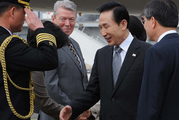 李대통령 런던 도착 이명박 대통령(가운데)이 영국 런던에서 열리는 주요 20개국(G20) 정상회의에 참석하기 위해 31일 런던 개트윅 공항에 도착해 영접을 나온 현지 인사들과 악수하고 있다. 오른쪽은 천영우 주영 대사. 런던=이종승 기자