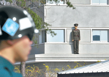 북한군, 창 난간에서 부동자세 경계8일 경기 파주시 비무장지대 판문점 북측 지역에서 북한 병사가 부동자세로 남측을 주시하고 있다. 로켓 발사로 전 세계의 이목을 집중시켰던 북한은 9일 최고인민회의 제12기 1차 회의를 열고 ‘김정일 체제’를 다시 한 번 견고하게 다지겠다는 태세다. 판문점=사진공동취재단