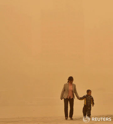 23일(현지 시간) 중국 간쑤성(甘肅省) 란저우(蘭州)에서 한 모자(母子)가 모래바람을 맞으며 걷고 있다. ⓒ로이터, 무단전재 및 재배포 금지