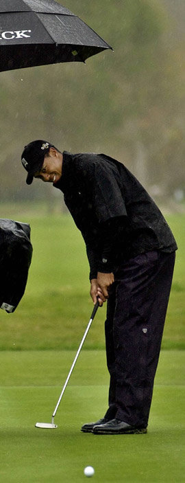 ‘골프 황제’ 타이거 우즈가 프로암대회에서 캐디가 우산을 받쳐주는 가운데 퍼트를 하고 있다. 비가 내리는 날 쇼트 게임은 핀을 직접 노리는 공격적인 샷을 해볼 만하다. 동아일보 자료 사진