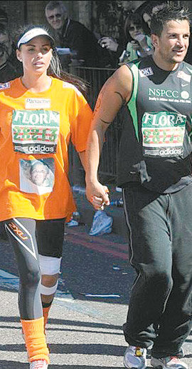 영국 모델 케이티 프라이스(왼쪽)가 26일 열린 런던마라톤 대회에서 남편인 가수 피터 안드레의 손을 잡고 절뚝거리며 걷고 있다. 그는 시각장애인 아들 사진이 프린트된 티셔츠를 입고 이 대회에 참가했다. 사진 출처 데일리메일닷컴