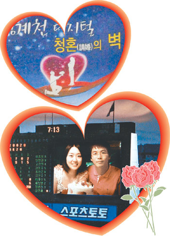 프러포즈를 위해 굳이 비싼 돈을 들이지 않아도 좋다. ‘5월의 신부’를 위해 프러포즈하려는 연인들에게 알맞은 다양한 프러포즈 장소가 서울 시내에 있다. 청계천 두물다리에 위치한 청혼의 벽(위)과 잠실운동장 전광판을 통해 청혼하는 젊은 연인들. 동아일보 자료 사진