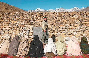 천막 하나도 없이…부르카를 뒤집어쓴 아프가니스탄 여성들이 천막도 없는 땡볕 아래서 수업을 듣고 있다. 이슬람 교리를 내세워 여성에 대한 교육을 금지한 탈레반의 정책 때문에 아프간 여성들은 기본 교육조차 제대로 받지 못하는 실정이다. 사진 제공 뉴스위크