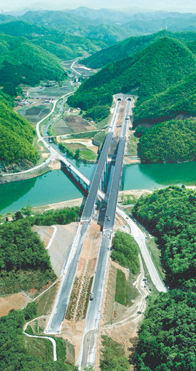 개통 앞두고 막바지 공사서울∼춘천 고속도로(61.4km)가 7월 개통을 앞두고 있다. 7일 강원 춘천시와 경기 가평군 경계지점인 발산1교 인근 고속도로가 시원스럽게 뚫려 있는 모습. 다리 밑으로는 홍천강이 흐르고 있다. 춘천=연합뉴스