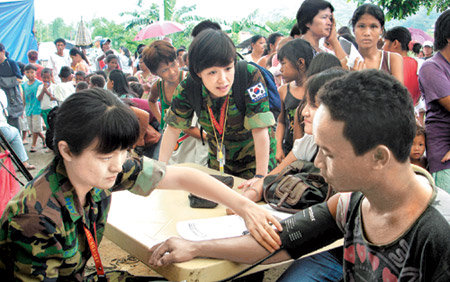 공군 간호장교인 한수경 대위(왼쪽)와 정지아 소령(가운데)이 10일 필리핀 루손 섬의 사팡바토 지역에 설치된 임시진료소에서 태풍 피해를 입은 현지 주민들을 진료하고 있다. 사진 제공 공군