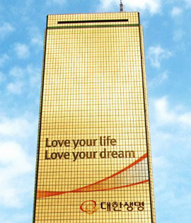 대한생명의 새로운 브랜드 슬로건인 ‘Love your life, Love your dream’으로 장식된 서울 영등포구 여의도동 대한생명 63빌딩 사옥. 사진 제공 대한생명