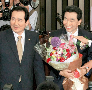 당대표-원내대표 어색한 동거? 15일 국회에서 열린 민주당 원내대표 경선에서 새 원내대표로 선출된 이강래 의원(오른쪽)이 당선이 확정된 직후 꽃다발을 받아 들고 정세균 대표와 함께 서서 환하게 웃고 있다. 연합뉴스