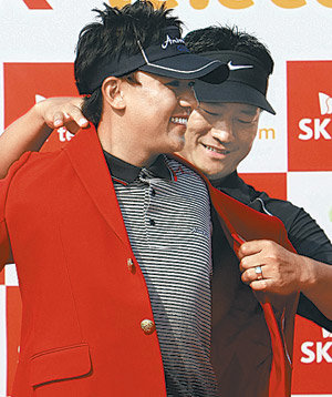 ‘축하합니다.’ 전년도 대회 우승자인 ‘탱크’ 최경주(뒤)가 2009 SK텔레콤오픈에서 우승한 박상현에게 이 대회 챔피언의 상징인 붉은색 재킷을 입혀주고 있다. 인천=연합뉴스