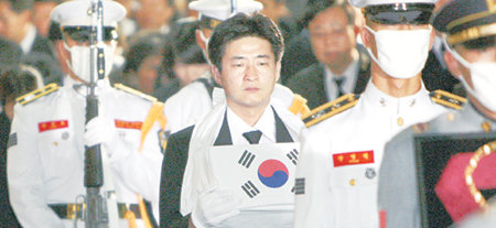 29일 노무현 전 대통령의 시신은 한줌의 재로 변했다. 이날 오후 경기 수원시 연화장에서 화장을 마친 노 전 대통령의 유골함을 아들 건호 씨가 들고 운구차로 이동하고 있다. 사진공동취재단