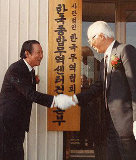 1985년 1월 한국종합무역센터 건설본부 현판식에서 박용학 대농 회장(왼쪽)과 악수하고 있는 남덕우 한국무역협회 회장.