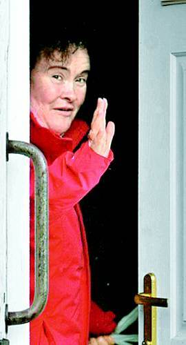 화장기 없는 얼굴에 피곤에 지친 표정의 수전 보일 씨가 스코틀랜드 자신의 집 앞 에서 기다리던 파파라치들에게 손을 흔들어 보이고 있다. 로스앤젤레스타임스