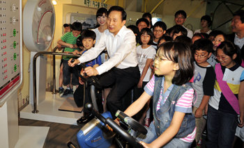 이명박 대통령이 4일 경기 용인시 수지구 풍덕천동 에너지관리공단의 녹색에너지 체험관을 방문해 손곡초등학교 어린이들과 함께 자전거발전기를 타고 있다. 용인=청와대사진기자단