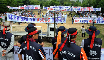 둘로 나뉜 쌍용차 8일 오전 경기 평택시 칠괴동 쌍용자동차 평택공장 후문 앞에서 쌍용차 직원 800여 명(회사 측 주장)이 개최한 생산정상화 촉구 궐기대회를 노조원들이 바라보고 있다. 정리해고에서 제외된 쌍용차 임직원들은 10일 다시 평택종합운동장에서 ‘쌍용차 정상화 촉구 결의대회’를 열 예정이다. 사진 제공 문화일보