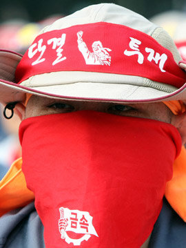 얼굴 가린 시위자 13일 오후 서울 영등포구 여의도 산업은행 앞에서 열린 민주노총 결의대회 참가자들이 얼굴을 마스크로 가린 채 ‘쌍용차 노동자 해고반대’ 구호를 외치고 있다. 연합뉴스