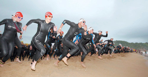 철인들, 동해 헤치고… 백두대간 넘어… ‘아름다운 지옥’을 달렸다 ‘비바람을 뚫고 바다를 향해 뛰는 철인들.’ 2009 하이원 국제트라이애슬론대회에 참가한 국내외 참가자들이 14일 강원 삼척해수욕장 모래사장에서 출발 총성과 함께 새벽 비를 가르며 바다로 내달리고 있다. 이날 500여 명의 참가자들은 삼척시, 태백시, 영월군, 정선군으로 이어지는 수영(3km), 사이클(80km), 달리기(20km) 코스에서 자신과의 싸움을 즐겼다. 삼척=특별취재반