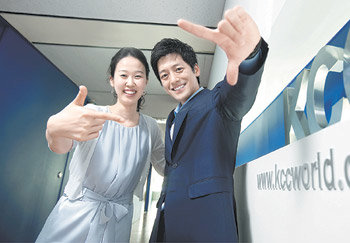 KCC 인사부 소속 정진이 씨(25·왼쪽)와 해외건재과 소속 차현준 씨(27)가 이 회사의 주요 생산품 중 하나인 창호 형상을 손가락으로 만들어 보이고 있다. 사진 제공 KCC