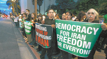 “이란에 민주주의를”이란 대선 결과에 불복해 정부에 맞서 시위를 벌이고 있는 이란인을 지지하는 미국인들이 24일 샌디에이고 주정부 청사 앞에서 ‘이란에 민주주의를, 모두에게 자유를’이라고 적힌 플래카드를 들고 시위로 숨진 이란인들을 추모하는 촛불집회를 열고 있다. 샌디에이고=로이터 연합뉴스