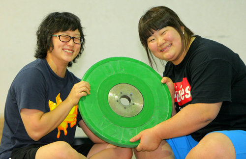 여자 역도 기대주 문유라(왼쪽)와 이희솔이 서울 태릉선수촌 역도장에서 묵직한 바벨 디스크를 쟁반 들듯 가볍게 맞잡고 환하게 웃고 있다. 원대연 기자