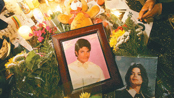 25일 사망한 ‘팝의 황제’ 마이클 잭슨을 추모하는 팬들이 미국 로스앤젤레스에서 촛불을 밝히고 생전 사진과 꽃, 선물 등을 바치며 기도하고 있다. 로스앤젤레스=AFP 연합뉴스