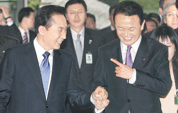 손잡은 한일 이명박 대통령(왼쪽)과 아소 다로 일본 총리가 28일 일본 도쿄 총리실에서 손을 맞잡고 다정한 모습으로 정상회담장으로 향하고 있다. 도쿄=연합뉴스