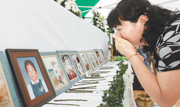 29일 오전 경기 화성시 서신면 백미리 ‘씨랜드 참사’ 현장에서 한 어머니가 흐느끼며 영정 속 자녀를 바라보고 있다. 유치원생 19명의 목숨을 앗아간 ‘씨랜드 수련원 화재사고’는 30일 10주년을 맞는다. 화성=연합뉴스