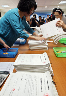 29일 오전 제주도선거관리위원회 직원들이 ‘김태환제주지사 주민소환운동본부’에서 제출한 주민 7만7000여 명의 소환 투표 청구인 명부를 살펴보고 있다. 제주=연합뉴스