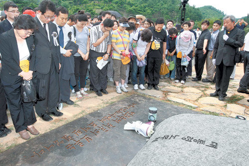 고 노무현 전 대통령 안장식이 열린 10일 경남 김해시 봉하마을에서 추모객들이 유해가 안장된 ‘아주 작은 비석’ 주위에 모여 고인을 추모하고 있다. 비석에는 조계종 총무원장 지관스님이 쓴 ‘대통령 노무현’이라는 여섯 글자가, 비석 받침에는 성공회대 신영복 교수가 쓴 ‘민주주의 최후의 보루는 깨어있는 시민의 조직된 힘입니다’라는 노 전 대통령의 어록이 새겨져 있다. 김해=사진공동취재단