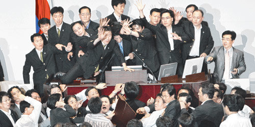 22일 국회 본회의장은 아수라장이었다. 이날 미디어관계법과 금융지주회사법을 표결 처리하려는 이윤성 국회부의장에게 민주당 강기정 의원이 나무판을 던지려 하자 한나라당 의원들과 국회 경위들이 막고 있다. 김경제 기자