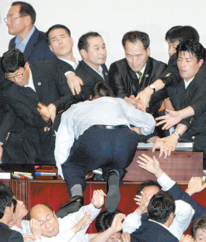 22일 국회 본회의장에서 민주당의 한 의원이 의장석 위로 뛰어올라 아슬아슬하게 앉아 있다. 이 의원은 국회 경위와 한나라당 의원들에게 떠밀려 단상 아래로 떨어졌다. 김경제  기자