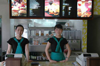 북한의 평양 금성네거리에 지난달 초 개업한 '속성음식 센터'(패스트푸드점)인 삼태성청량음료점의 종업원들. [연합뉴스]