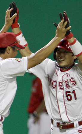KIA 김원섭(오른쪽)이 9일 군산구장에서 열린 SK와의 홈경기에서 2-3으로 뒤진 9회말 역전 끝내기 만루 홈런을 날린 뒤 3루를 돌며 최태원 코치와 하이파이브를 하고 있다. KIA는 이 홈런 한 방으로 9연승을 달렸다. 군산=연합뉴스