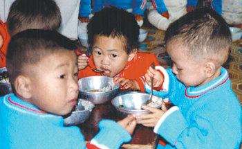 북한의 식량난이 극심했던 1997년 북한 어린이들이 배급된 식량으로 끼니를 때우고 있다. 동아일보 자료 사진