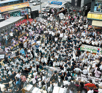 마주선 미디어법 찬반 집회민주당이 8일 서울 명동 입구에서 ‘미디어법 원천무효’를 주장하면서 서명운동(왼쪽)을 벌이자 보수국민연합, 대한민국어버이연합 등 보수단체 회원들이 ‘미디어법 조속시행’ 등의 피켓을 들고 민주당의 장외투쟁을 규탄하는 맞불 집회(오른쪽)를 열고 있다. 연합뉴스