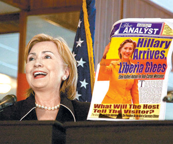 힐러리 클린턴 미국 국무장관이 13일 라이베리아 수도 몬로비아에서 엘런 존슨설리프 라이베리아 대통령과 함께 기자회견을 갖던 도중 자신의 사진이 실린 현지 신문을 들어 보이고 있다. 몬로비아=AFP 연합뉴스