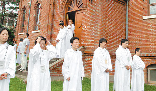 경북 칠곡의 성베네딕도회 왜관수도원 ‘수도생활 체험학교’에 참가한 사람들이 14일 오후 입교식을 마치고 잔디밭에 모였다. 서로의 등을 맞대는 의식을 통해 참가자들은 상대를 이해하는 마음을 조금씩 키워 나갔다. 앞줄 왼쪽에서 세번째가 본보 민병선 기자. 사진 제공 성베네딕도회 왜관수도원