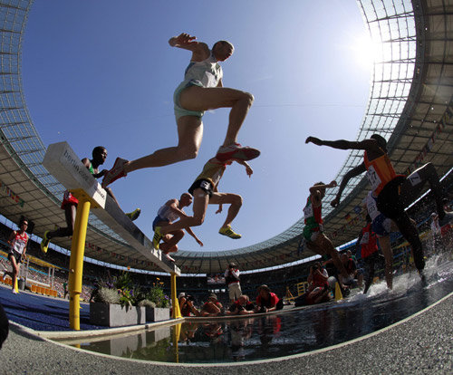 “장애물을 넘어” 16일 독일 베를린 올림피아 슈타디온에서 열린 세계육상선수권대회 남자 장애물 3000m 예선에 출전한 선수들이 물웅덩이 앞에 놓인 장애물을 뛰어넘고 있다. 베를린=EPA 연합뉴스
