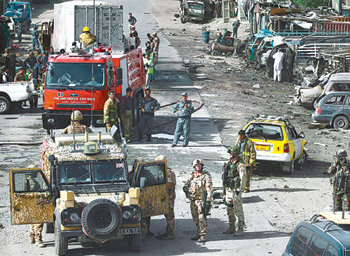 NATO 호위차량 테러 현장 18일 아프가니스탄 수도 카불 외곽에서 발생한 차량을 이용한 자살폭탄 테러 현장에서 연합군과 아프간 경찰이 경계를 서고 있다. 자살폭탄 테러범이 북대서양조약기구(NATO) 호위차량을 공격해 민간인 7명이 숨지고 연합군 장병을 포함한 50여 명이 다쳤다. 카불=AP 연합뉴스