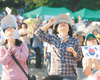25일 오후 전남 고흥군 영남면 남열해수욕장에 모인 관람객들이 한국 최초의 우주발사체 나로호가 하늘로 치솟아오르는 모습을 보며 성공을 기원하고 있다. 고흥=박영철  기자